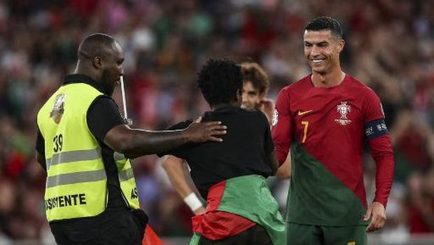 Cristiano Ronaldo tertawa di hadapan fans yang memeluknya. (Foto: AFP/CARLOS COSTA)
